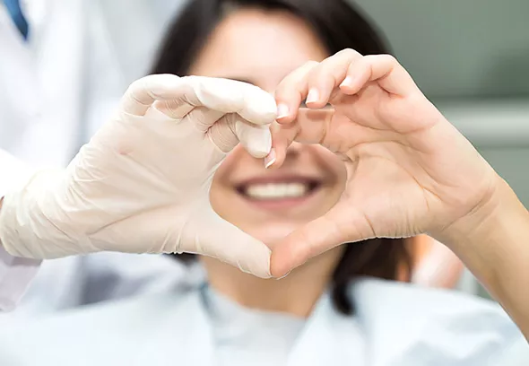 Patient and dentist making heart hand symbol